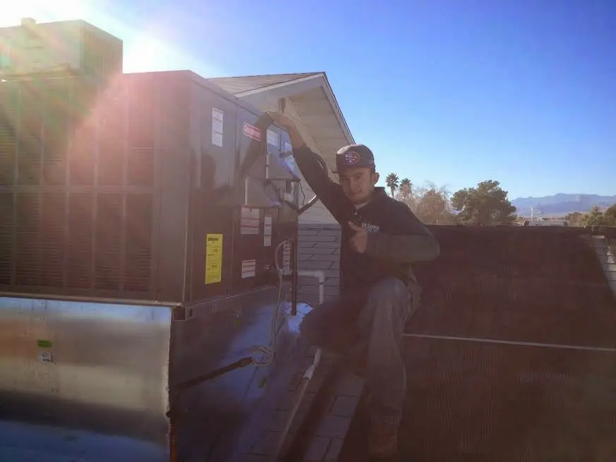 HVAC technician performing HVAC Inspection on a rooftop unit in Montville