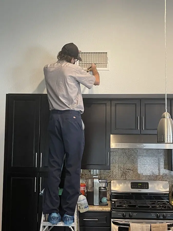 Technician inspecting an air vent during HVAC service in Montville